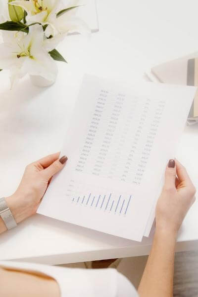 Person holding a printed report with bar chart and performance metrics, representing a WordPress website audit and technical analysis.