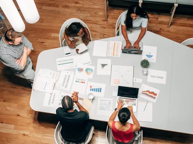 A digital agency team using Site Snapshot, reviewing website performance, analytics, and SEO reports around a table — discussing site monitoring, technical audits, and optimization strategies.